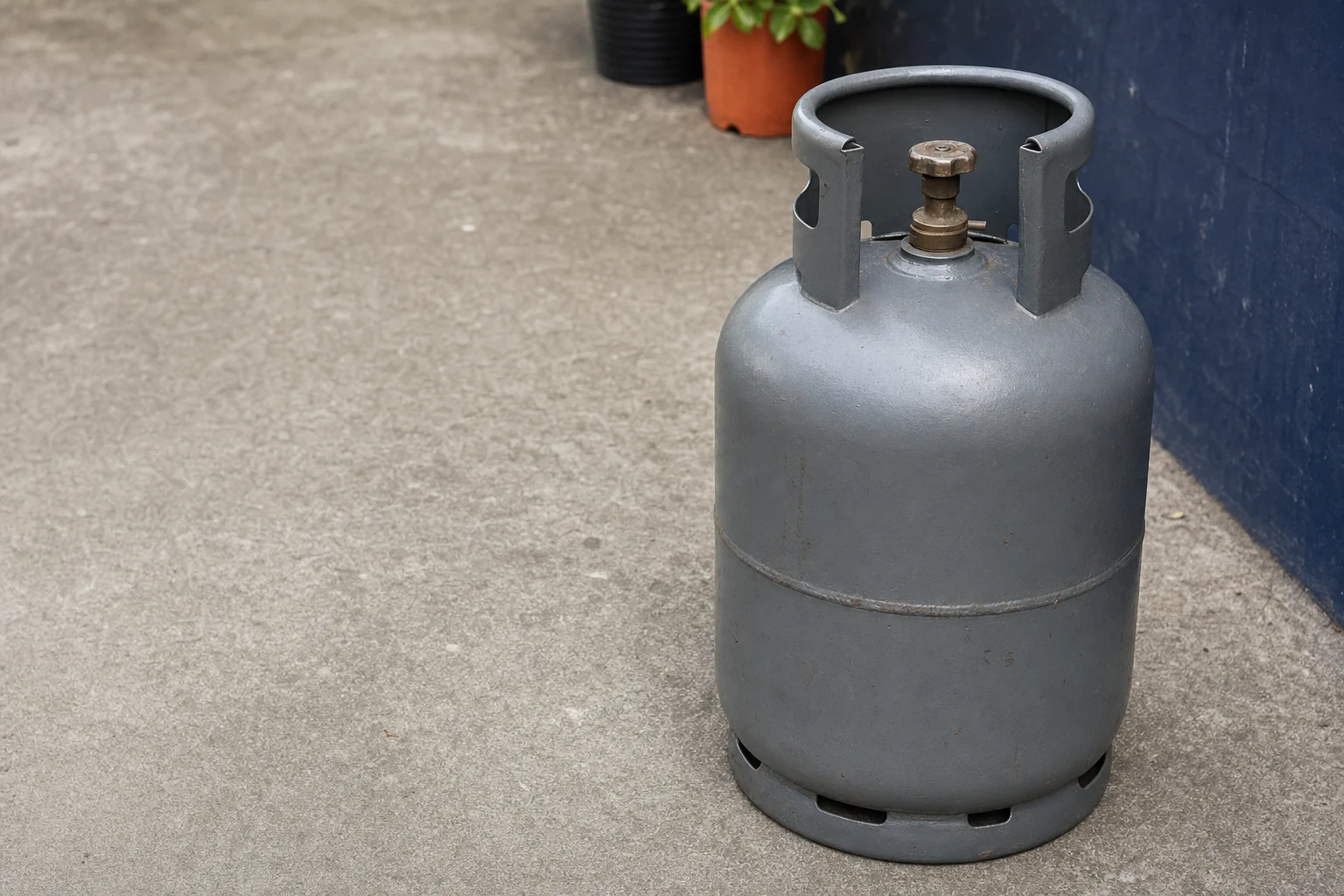 Cilindro de gas en posición vertical con la válvula hacia arriba sobre una base firme y nivelada al aire libre